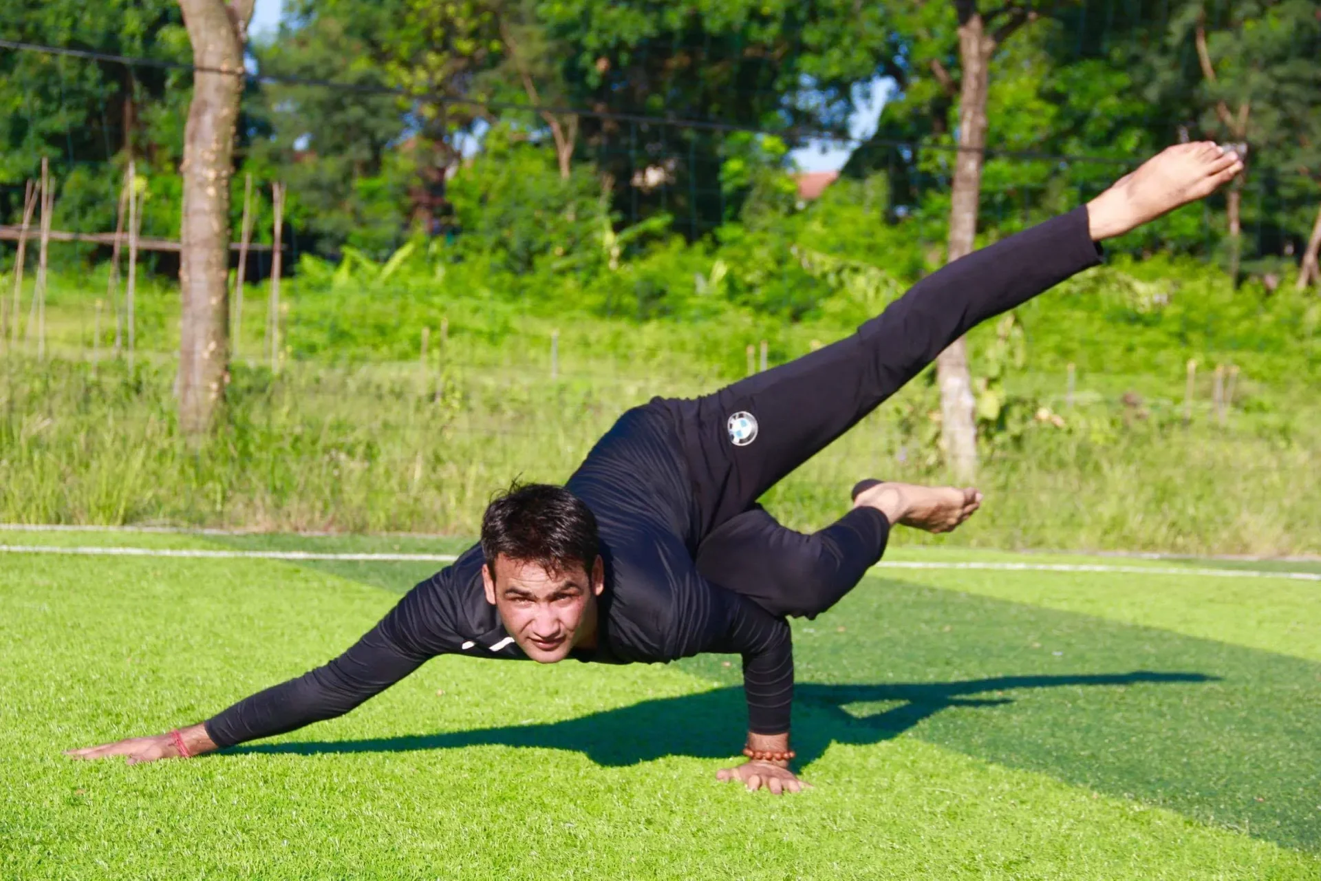 Master Anil holding an advanced arm balance with split legs